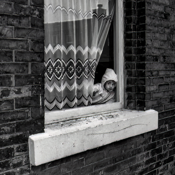 Child looking out from Terraced house window, Blackburn