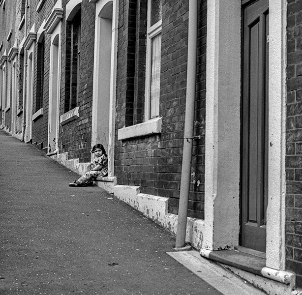 Young Child sat outside terraced houses - Blackburn a Town and Its People